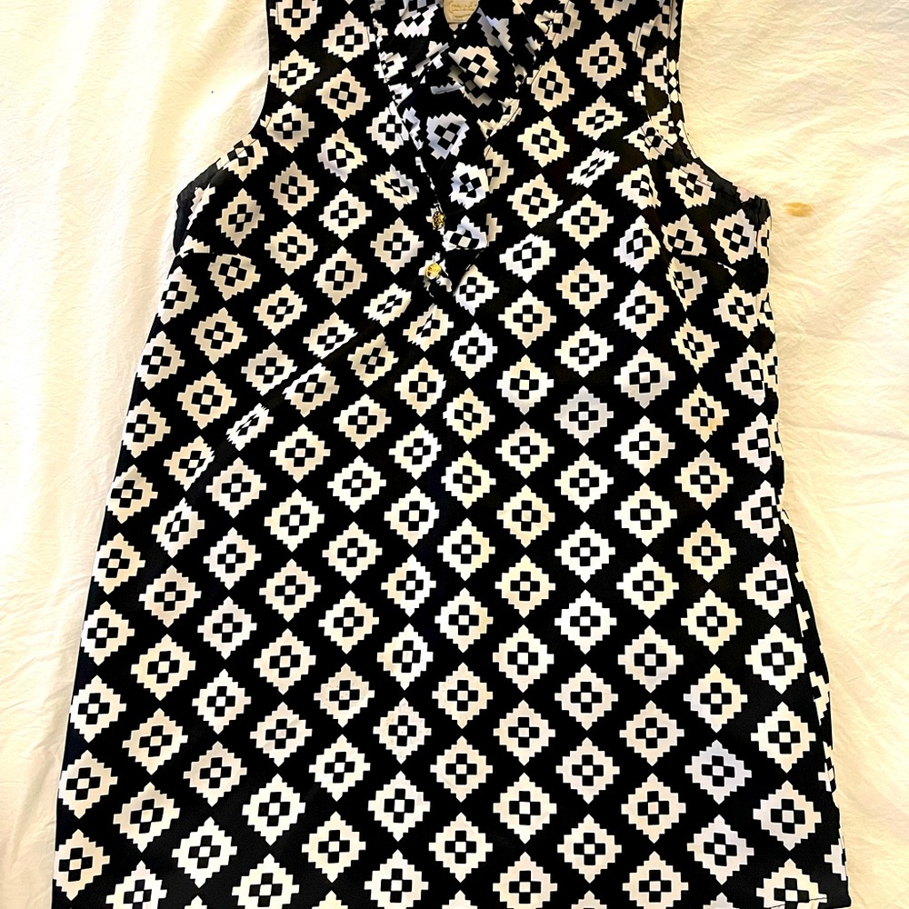 Black and white sleeveless blouse with ruffled neckline